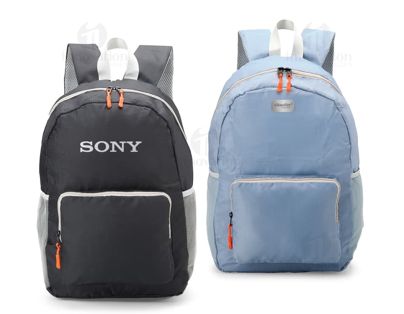 Mochila de Nylon Dobrável 23 Litros preta sendo segurada por um homem sorrindo, em um estúdio. O produto é um equipamento de viagem e possui zíper, alça, e é adequado para hiking, escola, negócios e lazer.