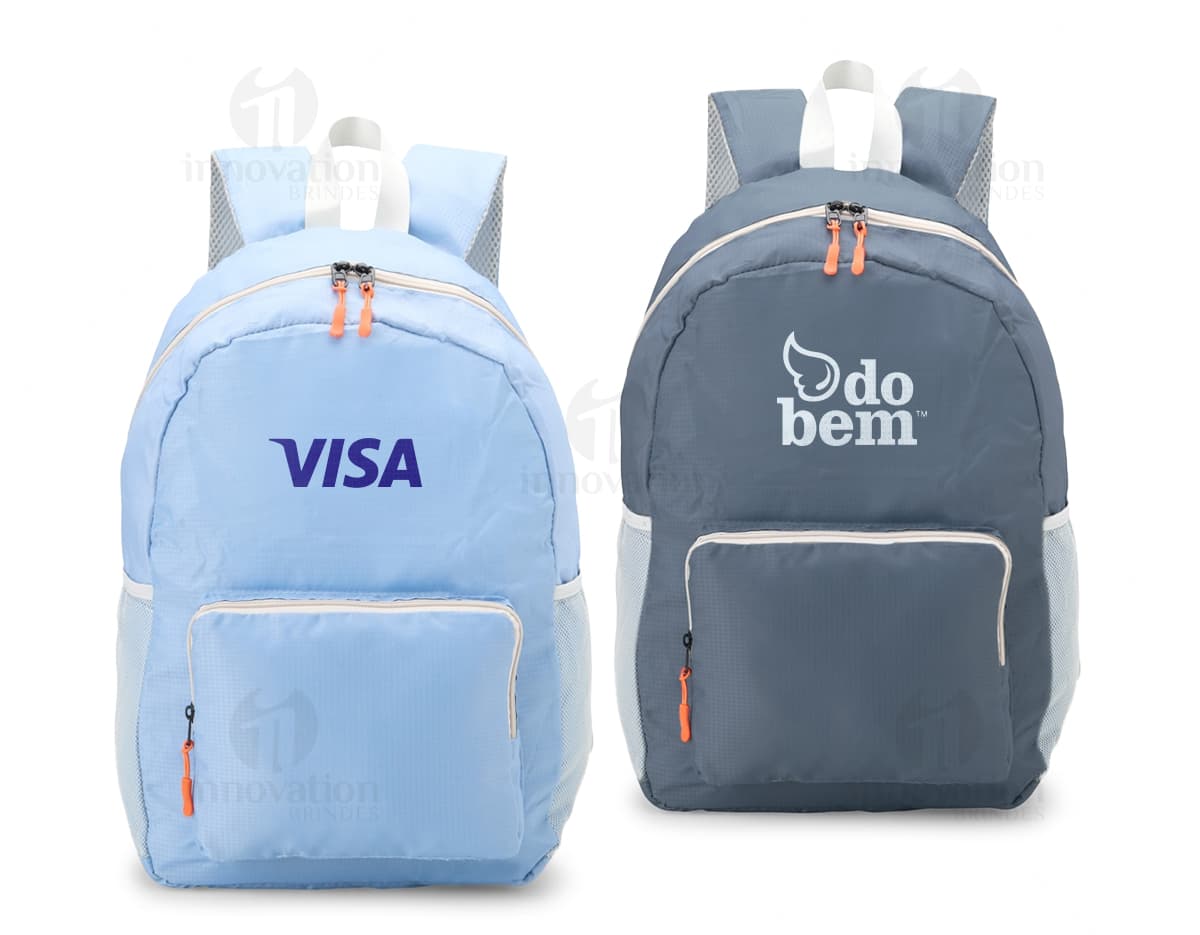 Mochila de Nylon Dobrável 23 Litros preta sendo segurada por um homem sorrindo, em um estúdio. O produto é um equipamento de viagem e possui zíper, alça, e é adequado para hiking, escola, negócios e lazer.
