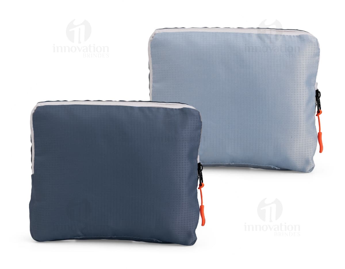 Mochila de Nylon Dobrável 23 Litros preta sendo segurada por um homem sorrindo, em um estúdio. O produto é um equipamento de viagem e possui zíper, alça, e é adequado para hiking, escola, negócios e lazer.