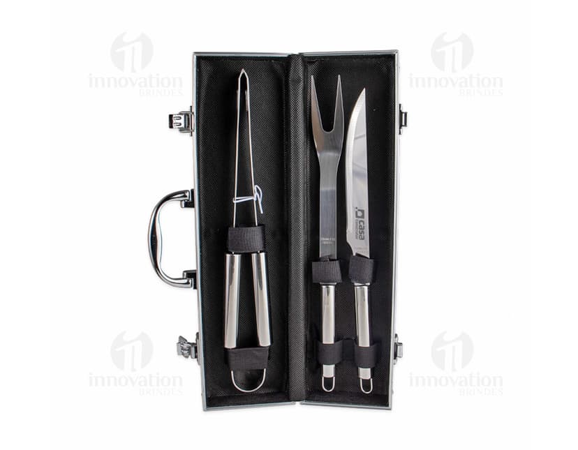 Kit Churrasco 3 Peças em aço inoxidável, contendo faca, garfo e pegador, sobre fundo branco.