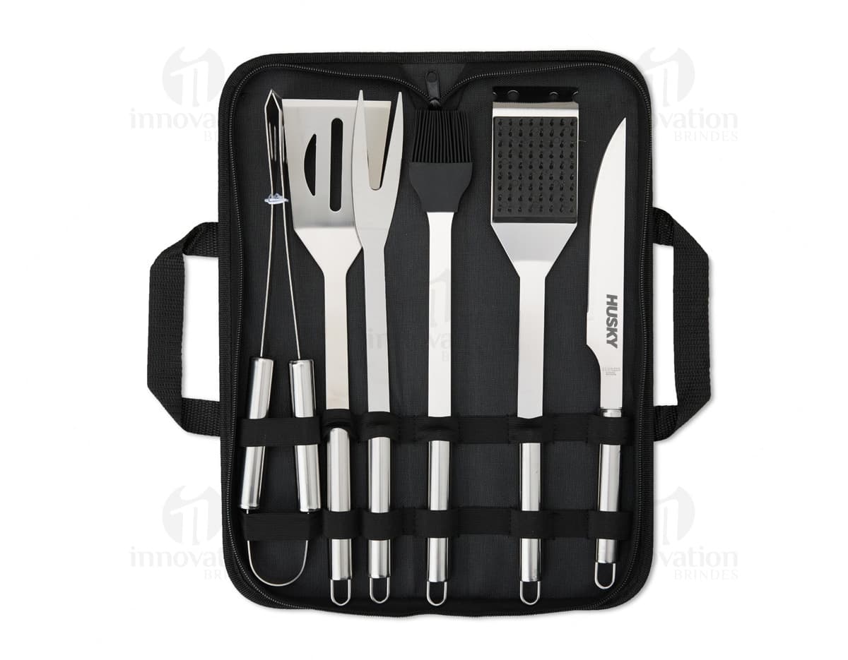 Imagem de um Kit Churrasco 6 Peças, contendo ferramentas e utensílios para churrasco, como faca, garfo, espátula, pegador e escova, em uma maleta de couro preta.
