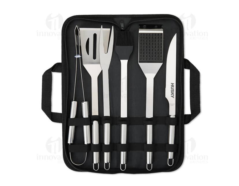 Imagem de um Kit Churrasco 6 Peças, contendo ferramentas e utensílios para churrasco, como faca, garfo, espátula, pegador e escova, em uma maleta de couro preta.