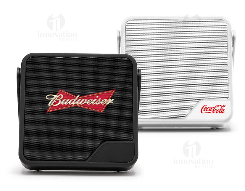 Caixa de som preta com botões de controle de volume e conexão Bluetooth no lado direito e textura de tecido na parte frontal.