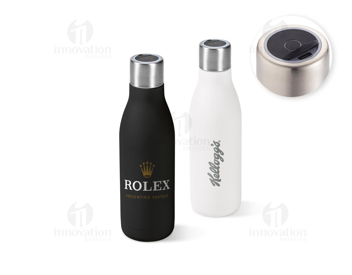 Garrafa em aço inox contendo bebida alcoólica, com tampa de cortiça. A garrafa está vazia e possui rótulo em branco. Está em pé sobre uma superfície de vidro, com reflexo no fundo escuro. A imagem é vertical e destaca a elegância e luxo do produto.