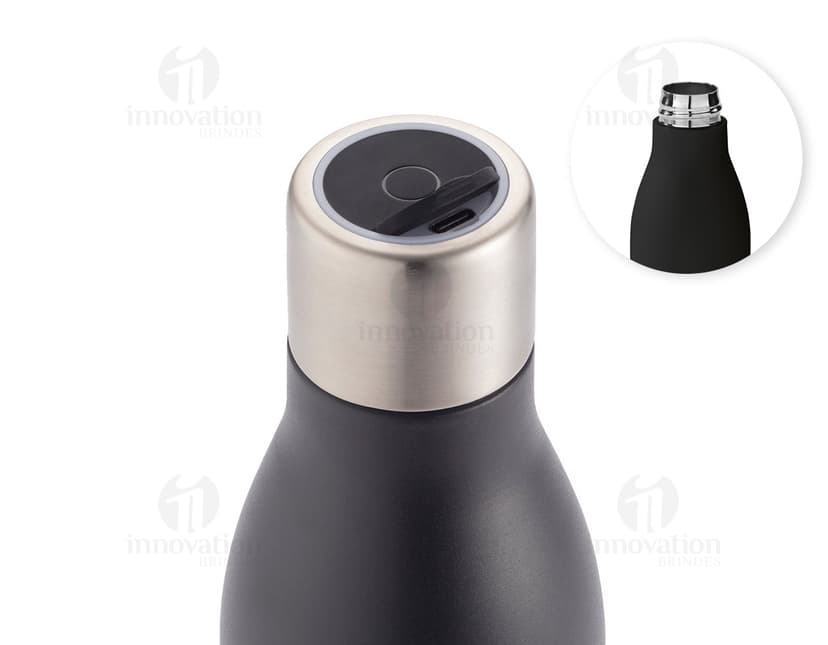 Garrafa em aço inox contendo bebida alcoólica, com tampa de cortiça. A garrafa está vazia e possui rótulo em branco. Está em pé sobre uma superfície de vidro, com reflexo no fundo escuro. A imagem é vertical e destaca a elegância e luxo do produto.