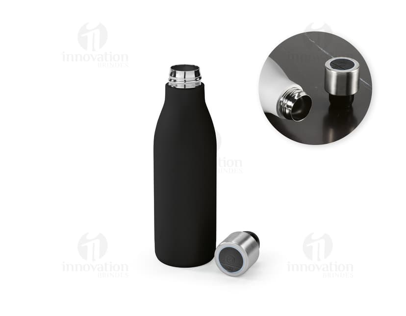 Garrafa em aço inox contendo bebida alcoólica, com tampa de cortiça. A garrafa está vazia e possui rótulo em branco. Está em pé sobre uma superfície de vidro, com reflexo no fundo escuro. A imagem é vertical e destaca a elegância e luxo do produto.