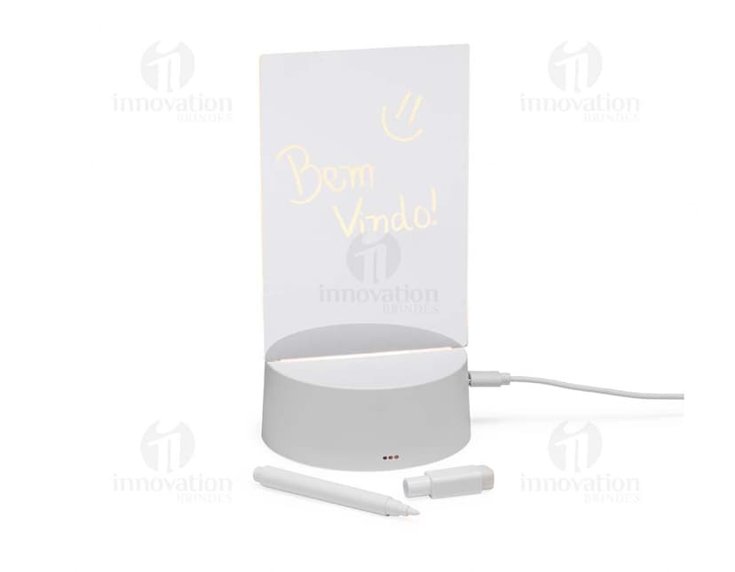 Luminária Led de Mesa na cor preta, com hastes flexíveis e base redonda. Acesa, iluminando um ambiente com luz branca.