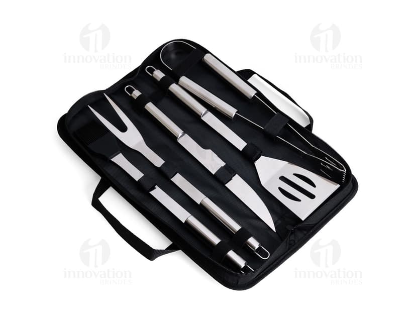 Kit Churrasco 5 Peças - Conjunto contendo faca, garfo, pinça, espátula e escova para churrasco em fundo de madeira.