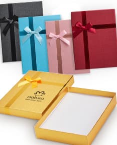 Caixa de presente na cor vermelha, com laço dourado e pequenos detalhes brilhantes.