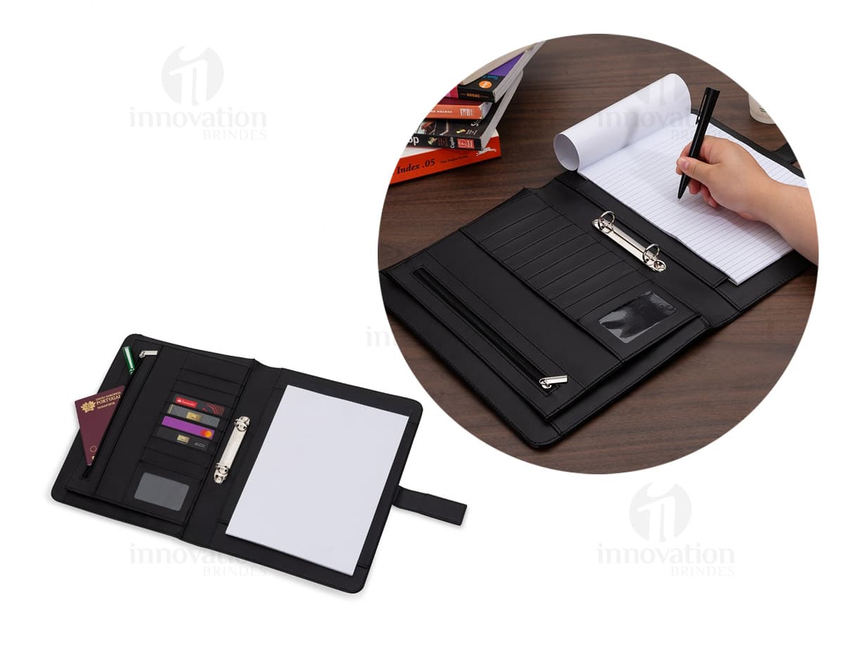 Pasta de convenção com fecho imantado em cor preta, vista de cima e aberta mostrando organização interna com divisórias e suporte para bloco de anotações. Pasta de convenção com fecho imantado em cor preta, vista de cima e aberta mostrando organização interna com divisórias e suporte para bloco de anotações.